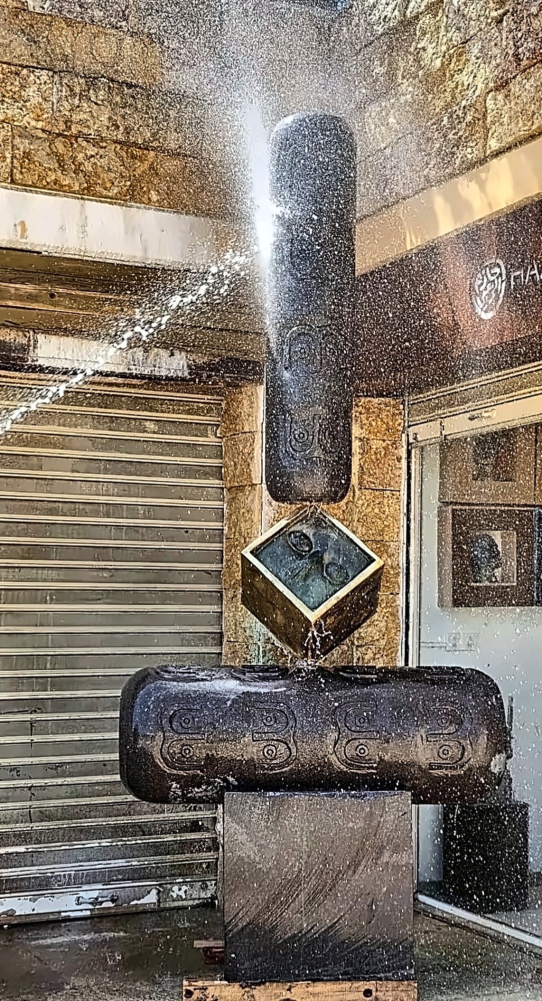 Water falling over the black stone, the surface running wet.