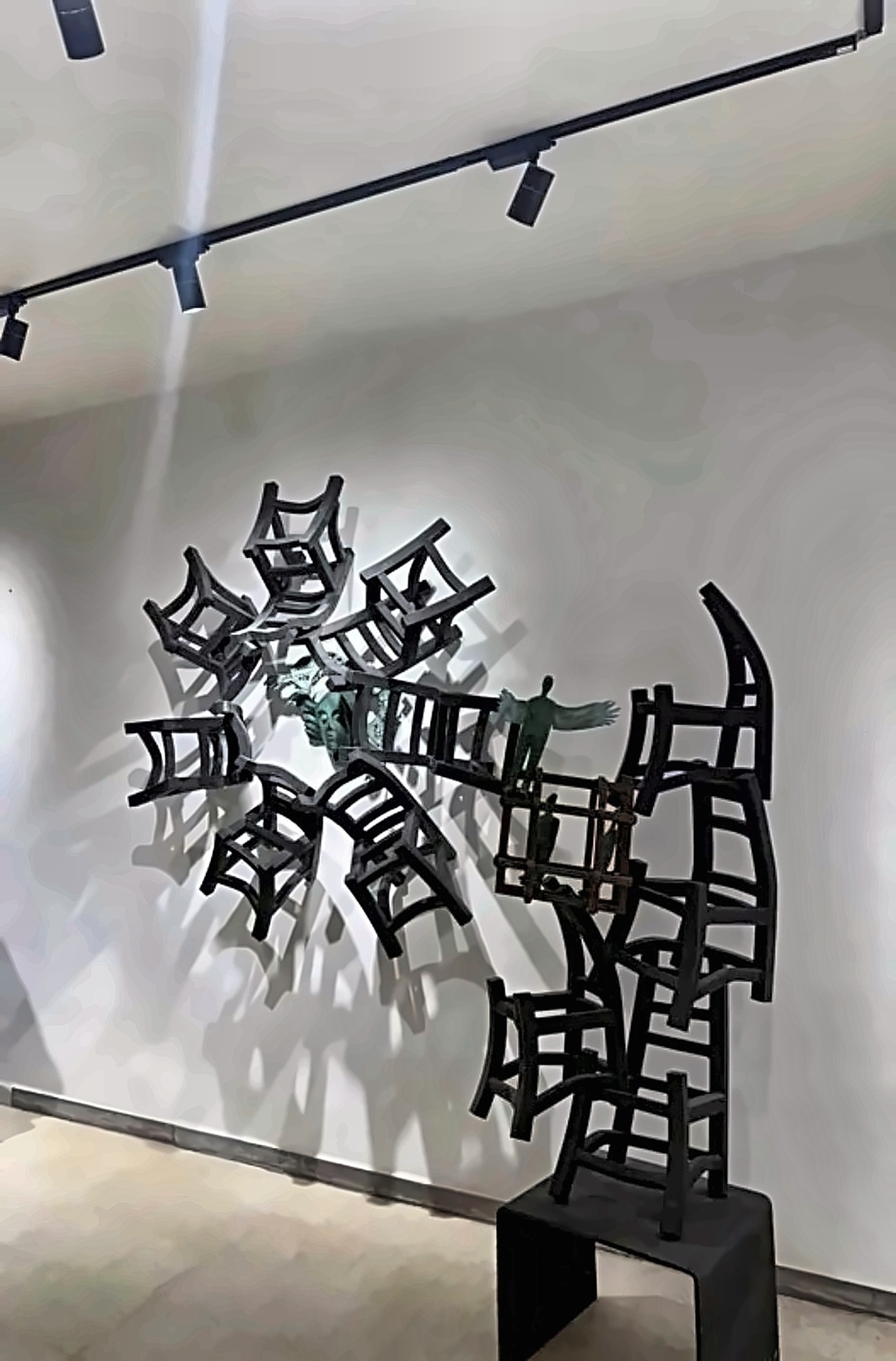 A wall sculpture formed from chairs.