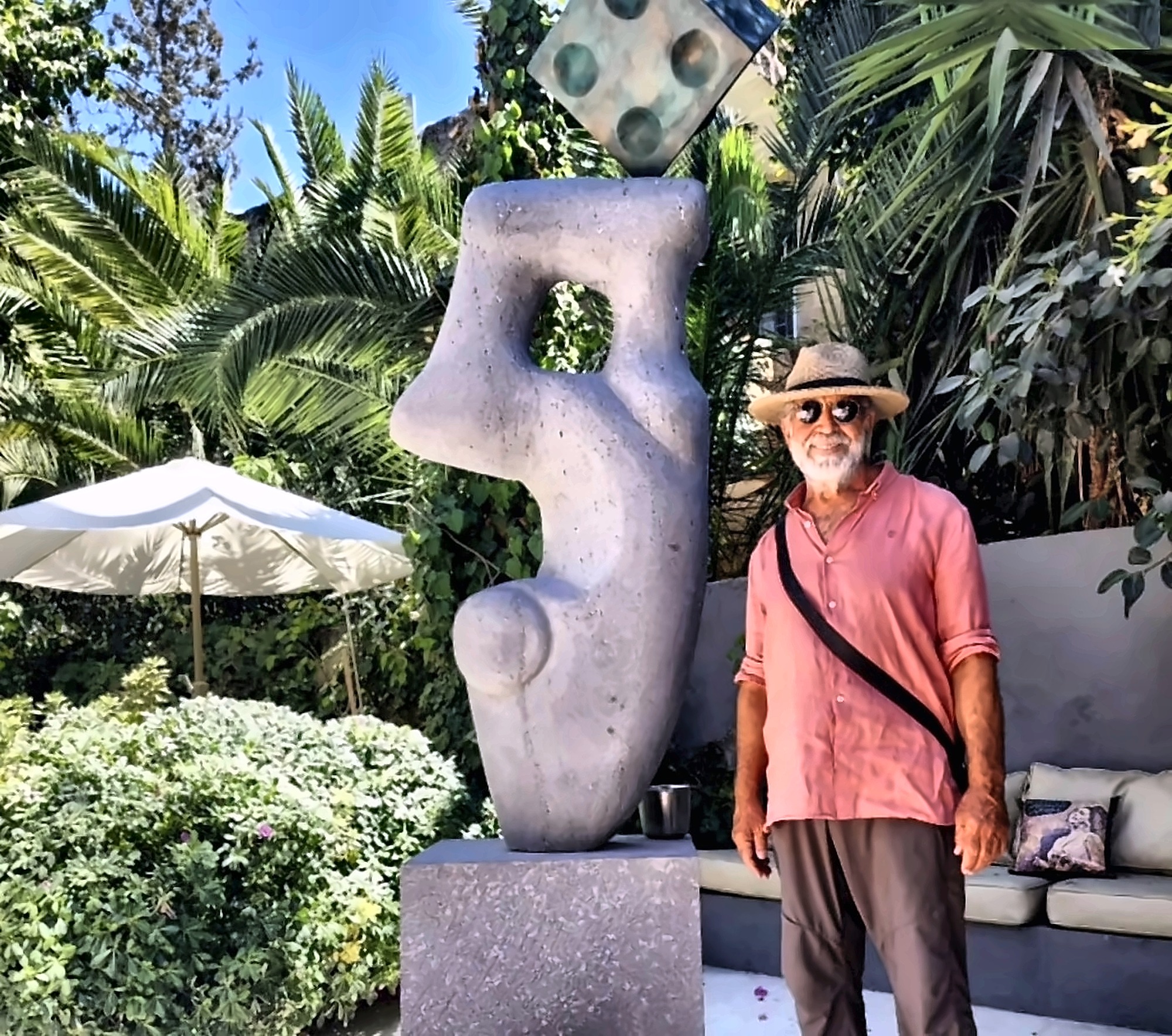 A carved stone with a bronze cube, installed in a garden.
